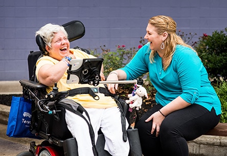 two adult Citizen program participants sitting and laughing