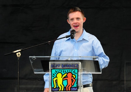 Male Buddy Ambassador speaking at an event podium