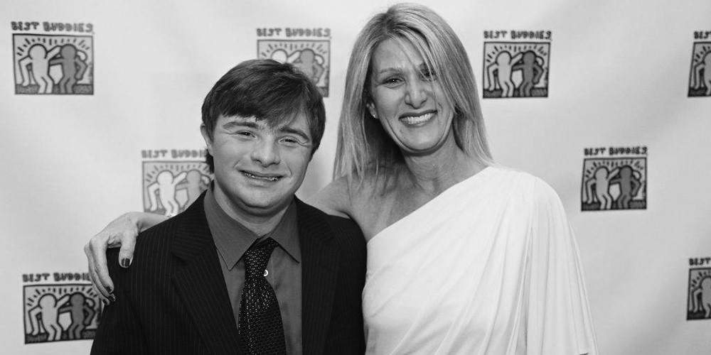 Nina Greene and son, Randy in front of Best Buddies backdrop