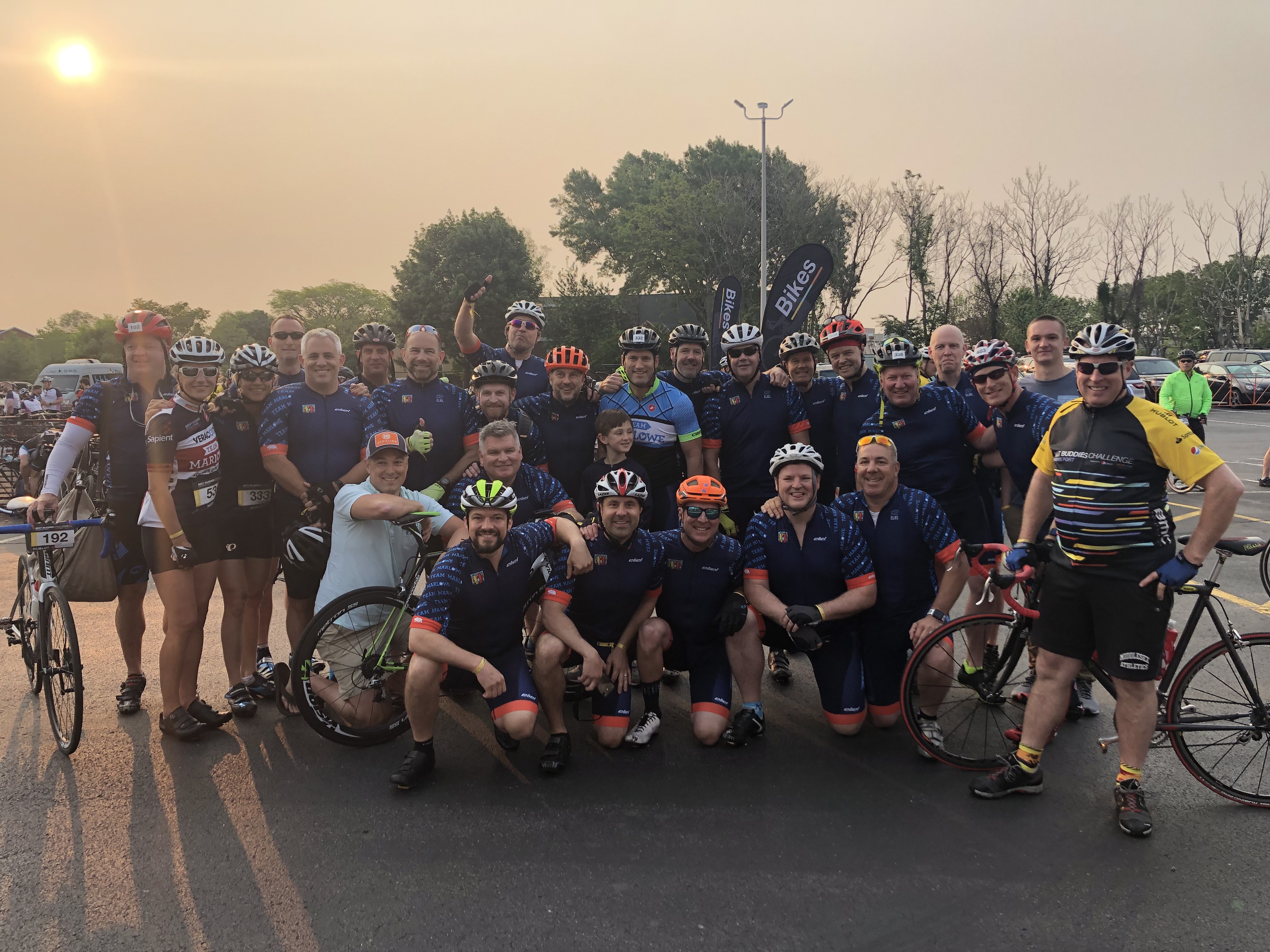 a large group of cyclist gathered kneeling and standing for a picture