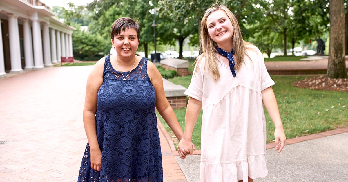 Best Buddies Citizens pair holding hands and smiling outside