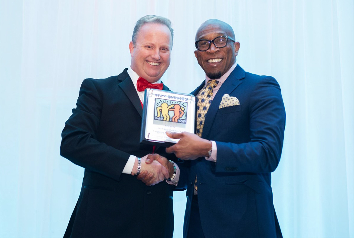 Two Men Holding Best Buddies Excellence Award Plaque