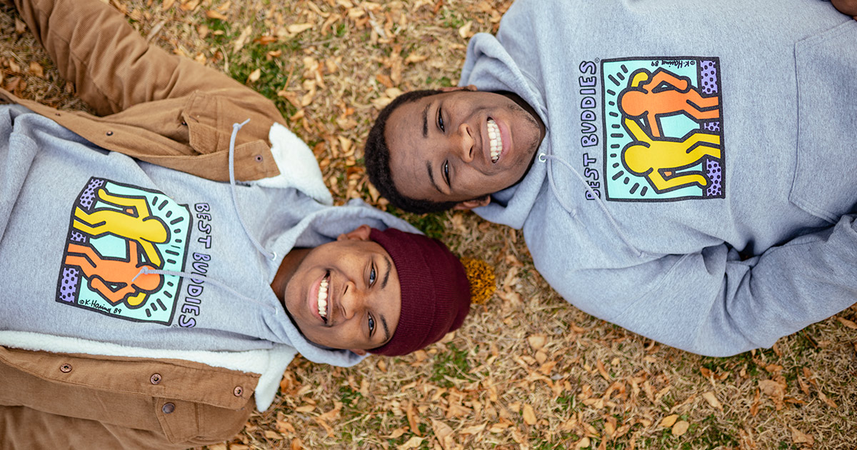 Two African American teenagers smiling in Best Buddies hoodies