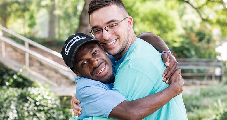 To Best Buddies participants hugging and smiling