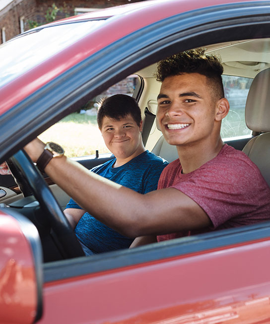 Two male program participants driving in a car