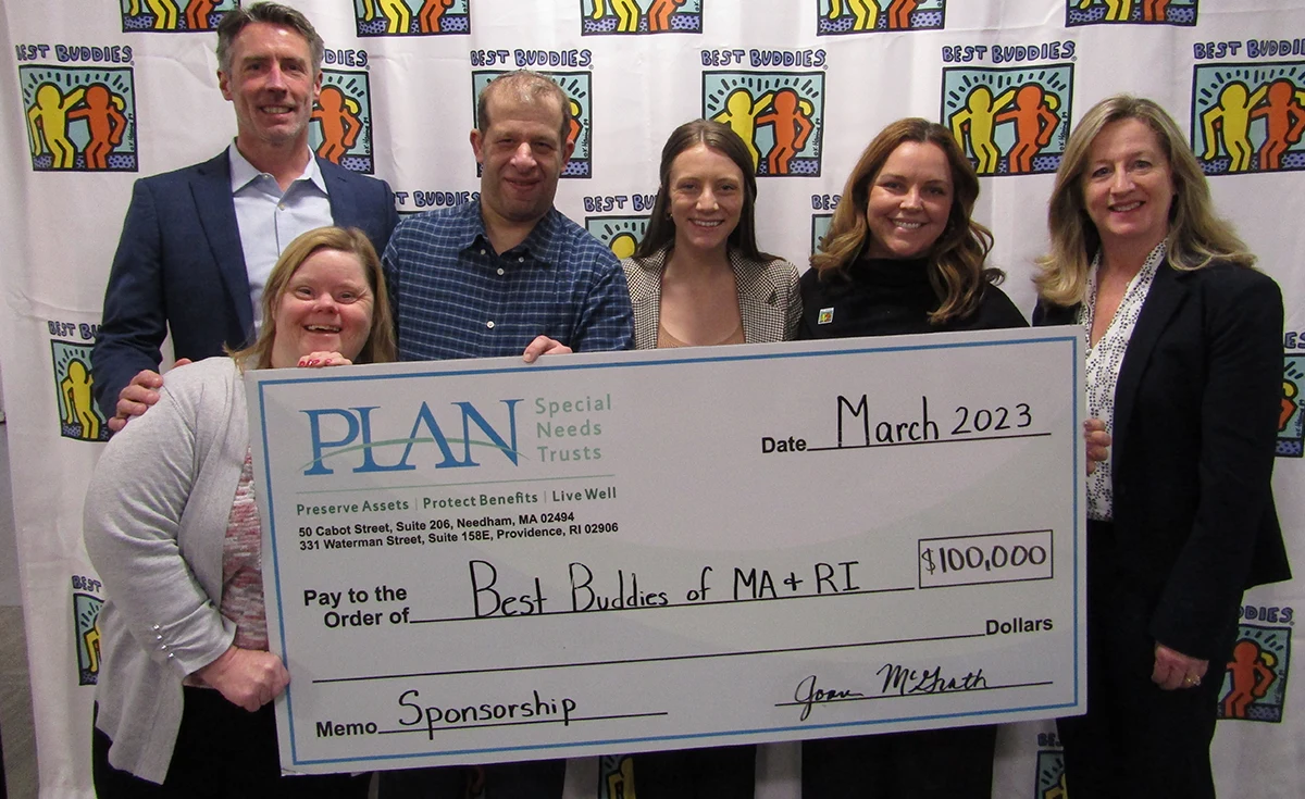 Group of Best Buddies staff and supporters holding a large $100K check