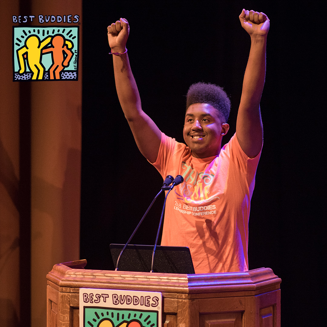 Buddy Ambassador Joshua Felder at a podium with his hands raised