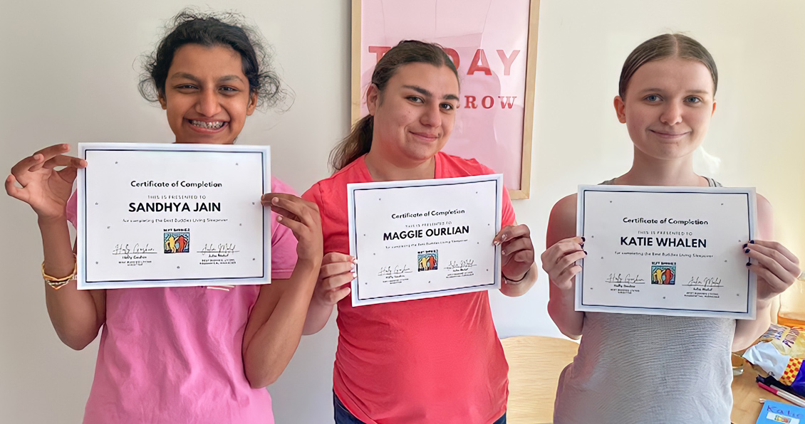 Three girls proudly show their Certificate of Completion for the Best Buddie's Sleepover.