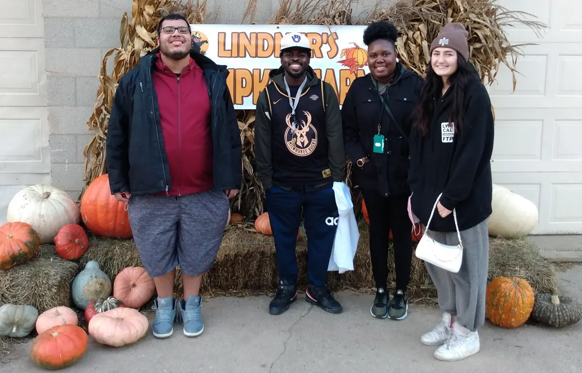 Best Buddies in Wisconsin participants smiling for the camera at the Pumpkin Patch event