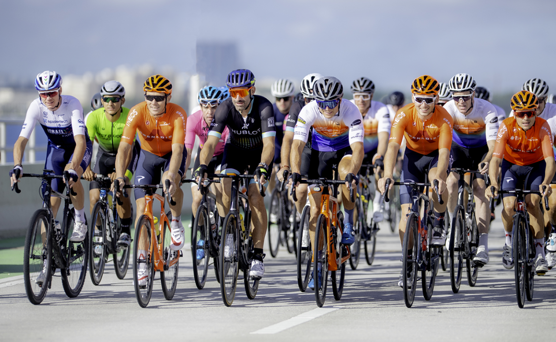 A group of cyclists ride in the Best Buddies Challenge: Miami over the the MacArthur Causeway. A cruise ship in the Port of Miami can be seen in the background.