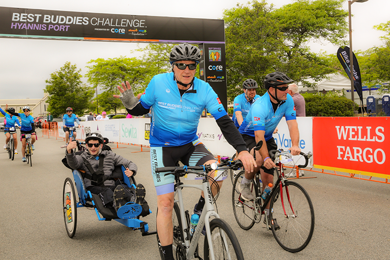 A cyclist in the Buddies Challenge: Hyannis Port, pulls a Best Buddies participant through to the finish line.