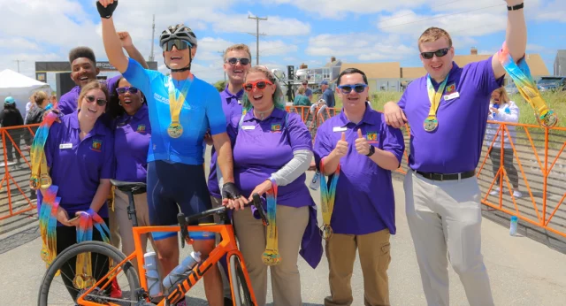 Best Buddies Founder and CEO, Anthony Shriver is surrounded by seven Best Buddies Ambassadors at the finish line at the Best Buddies Challenge: Hyannis Port.
