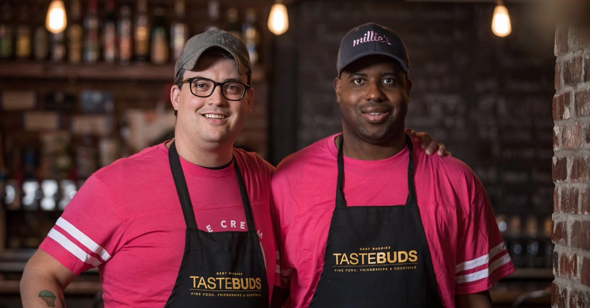 Two men wearing aprons with the Tastebuds logo