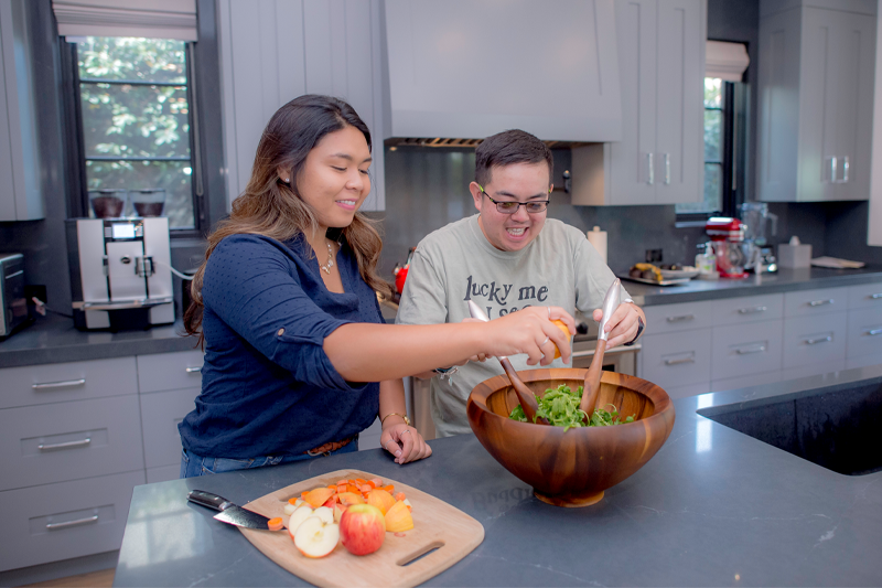 Two Best Buddies Living Residents prepare a salad in their shared kitchen in Los Angeles, California.