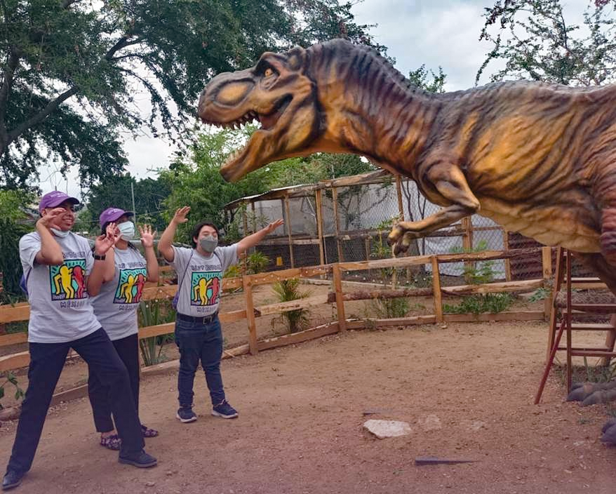 A group of Best Buddies Mexico participants visit the Cretacean Museum and are posing with a dinosaur.