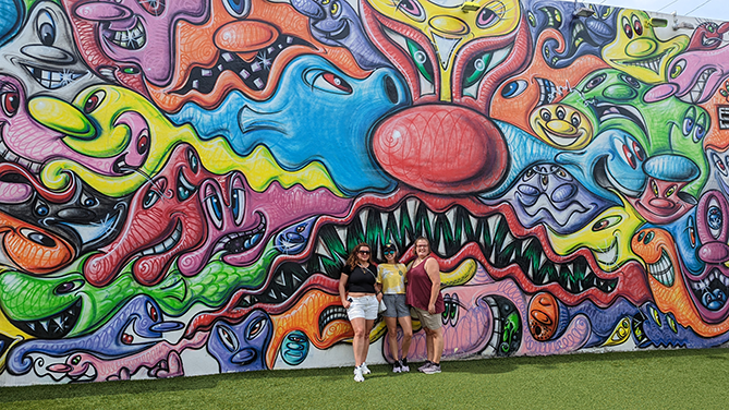 Three Best Buddies Living participants stand against a graffitied wall in Wynwood, Miami.
