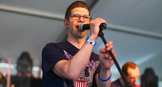 Bret Fleming singing on stage at a Best Buddies Challenge event