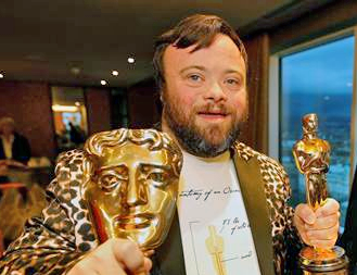 Actor James Martin holds an Oscar Trophy in his left hand.