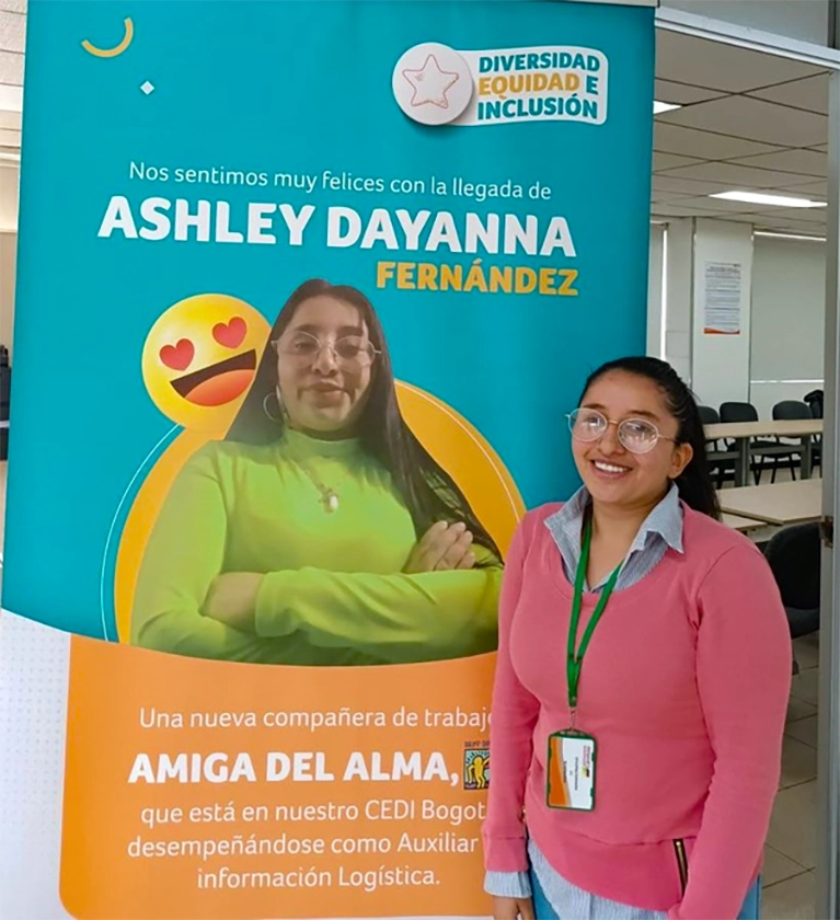 A Best Buddies Job participant poses in front of a banner with her image on it.
