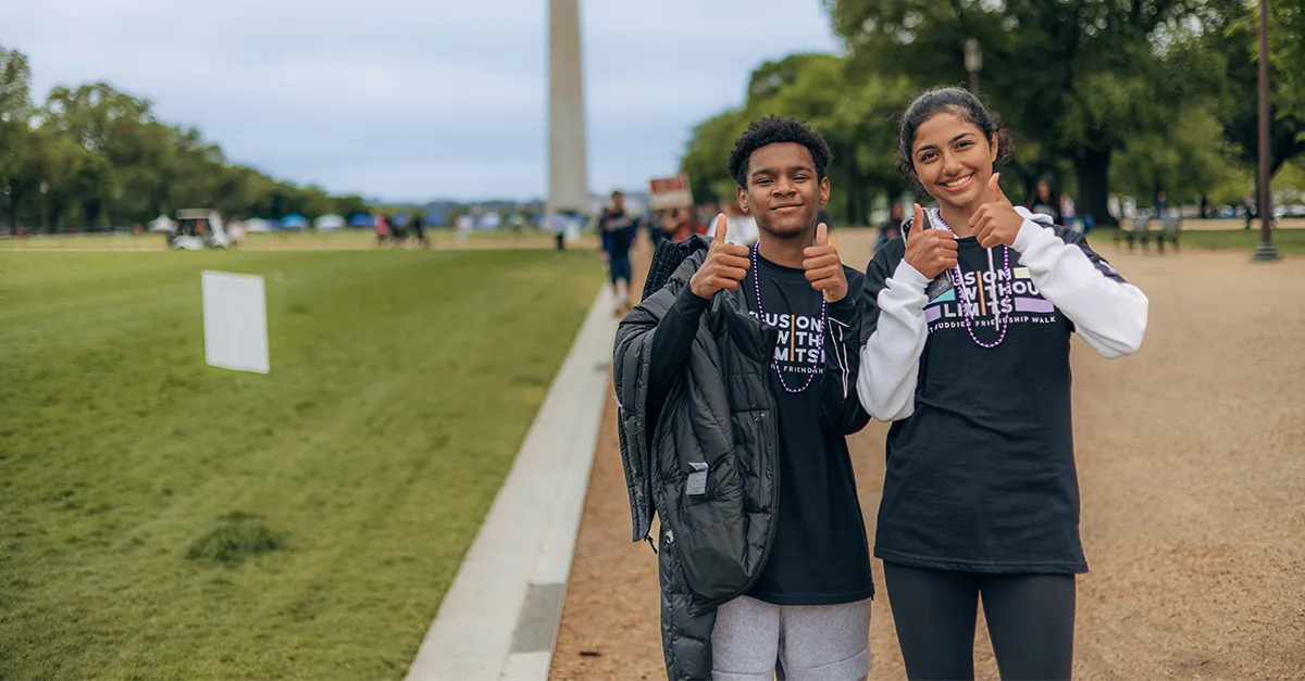Two best buddies participants on the national mall giving thumbs up signs