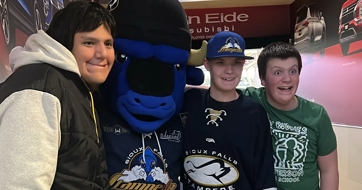 students with mascot at hockey game