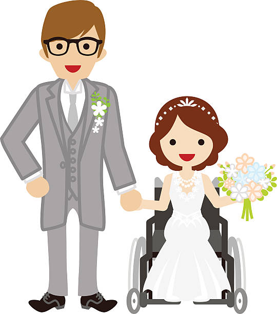 A bride and groom holding hands and smiling. The groom has glasses and is in a wheelchair. The bride is standing holding a bouquet of blue, pink and white flowers.