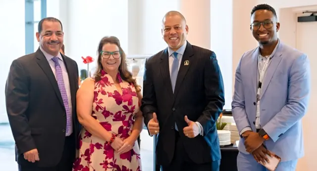Best Buddies programme to launch in Cayman schools - featured image Four leaders at the Uncharted conference—Education Minister Rolston Anglin, Inclusion Cayman CEO Shan Harriman, Premier André Ebanks, and facilitator Nathan Chesney—standing together and smiling indoors.