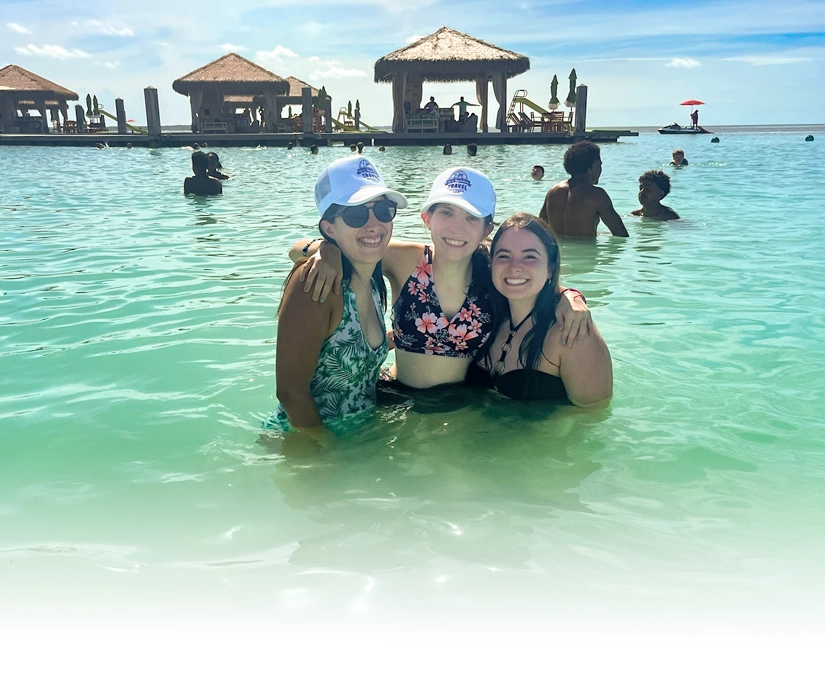 Announcing Best Buddies Travel - Connecting Through Inclusive Travel Experiences -2nd image Three Best Buddies participants smiling together in the water during a group travel experience.