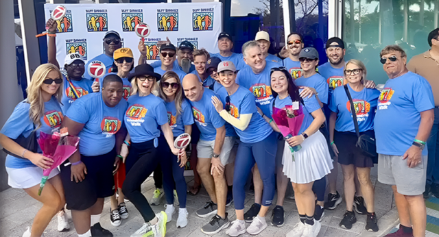 Group of participants posing together in matching shirts at the Best Buddies Friendship Walk event.