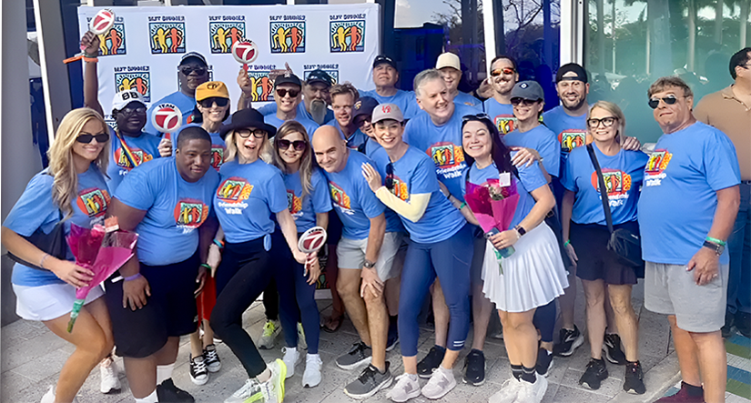Attendees walk for a good cause at loanDepot Park for 5th annual Ed Ansin Best Buddies Friendship Walk - Image Group of participants posing together in matching shirts at the Best Buddies Friendship Walk event.