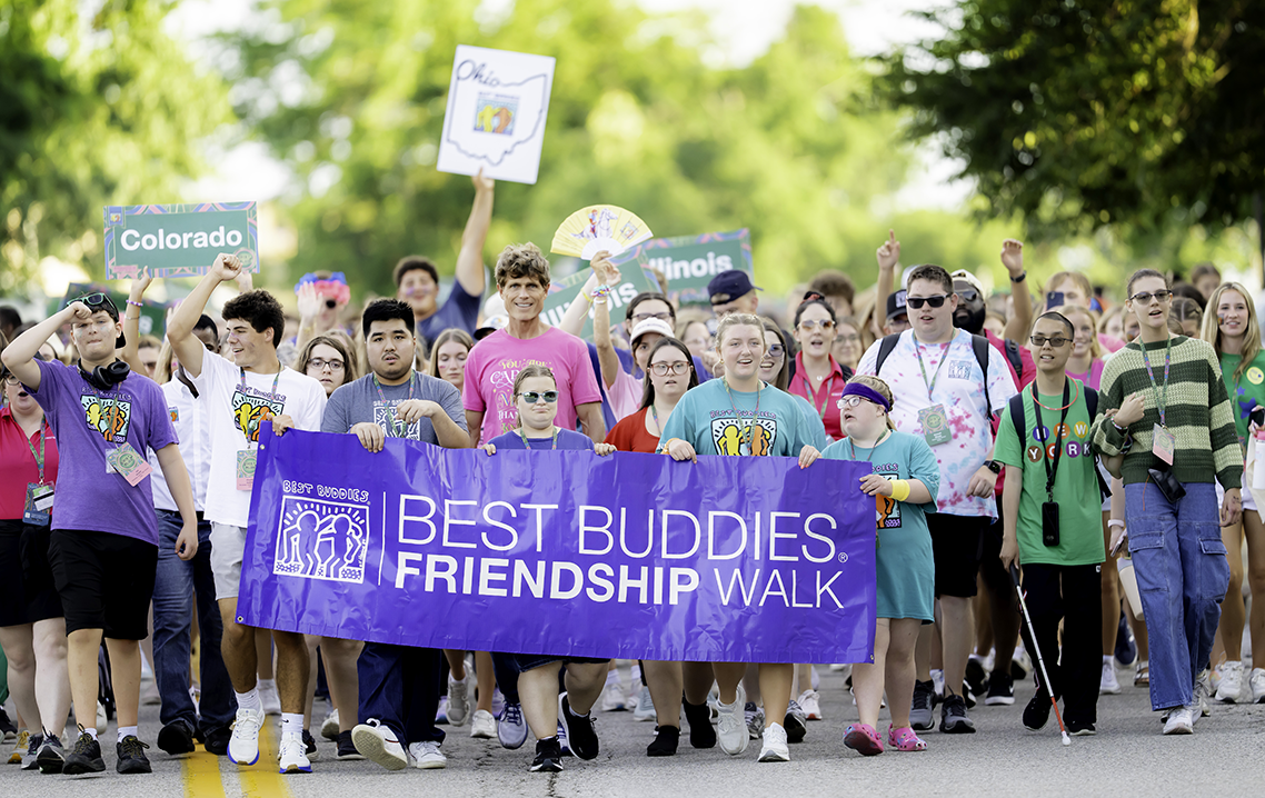 Participants of all abilities lead the Best Buddies Friendship Walk, carrying a Best Buddies Friendship Walk banner while supporters from across the country follow behind.