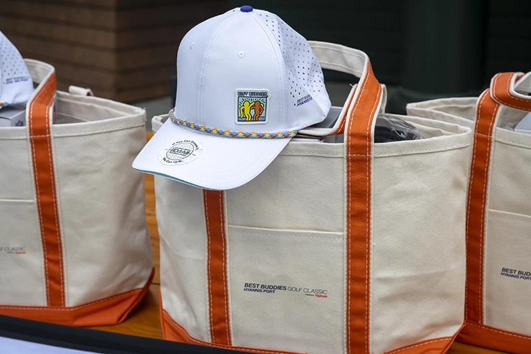 2026 News Golf 3 Best Buddies golf hat displayed on a tournament tote bag.