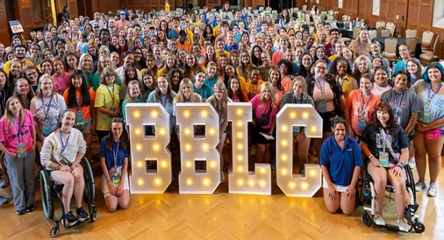 206 News Inclusion promoted feature image Large group of Best Buddies Leadership Conference participants posing with illuminated BBLC letters