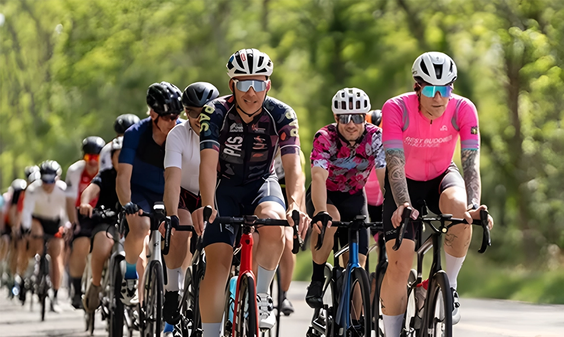 2026 BBC New York Challenge Press release Cyclists riding together along a tree-lined route during a Best Buddies Challenge.