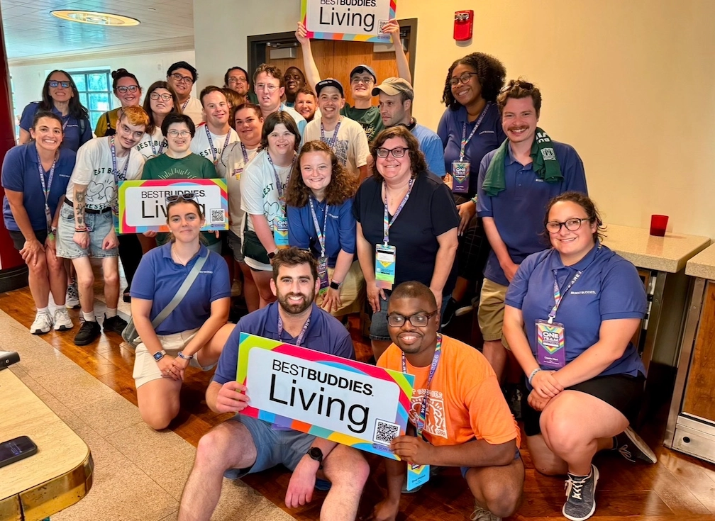 2026 Landmark Post image 2 Best Buddies participants and staff posing together while holding Best Buddies Living signs.